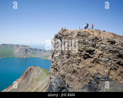 Westliche Touristen auf vulkanischen Gipfel der nordkoreanischen Seite des Mount Paekdu mit Blick auf den Kratersee. Nordkorea / Nordkorea Stockfoto