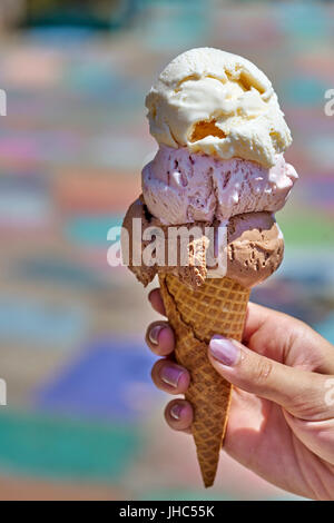 Sommer-Genuss: weibliche Hand Holding drei Kugel Eis Waffelhörnchen Stockfoto