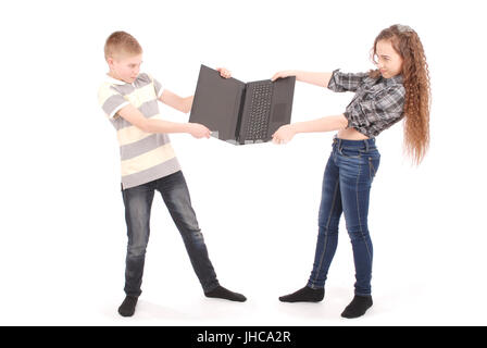 Jungen und Mädchen kämpfen über einen Laptop, isoliert auf weiss Stockfoto