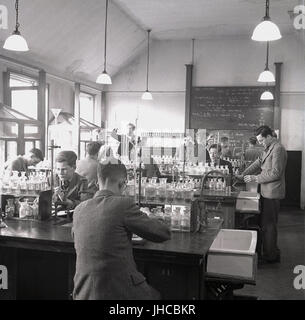 1950, historische, school Jungen tun Chemie Experimente in einem gut sortierten Science Laboratory in Mill Hill School, eine traditionelle britische Gebühr Jungen zahlen nur Internat im Norden von London, England, UK. Stockfoto