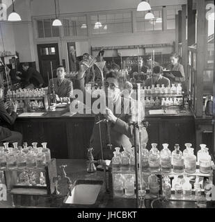 1950, historische, school Jungen tun Chemie Experimente in einem gut sortierten Science Laboratory in Mill Hill öffentliche Schule, einem traditionellen Briitsh Jungen nur Gebühr zahlen Internat im Norden von London, England, UK. Stockfoto