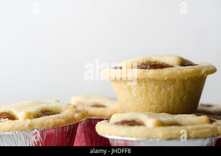 Eine Ebene Vogelperspektive eines Stapels von Weihnachten Mince Pies mit Stern geformte Topper in Zinn (Aluminium) Folie mit textfreiraum oben. Stockfoto