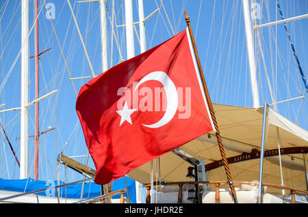 Bodrum Hafen, Türkei. Große türkische Fahne auf Schiff hinter Masten und blauer Himmel. Stockfoto