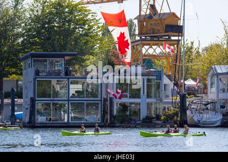 Kajaks Reihe vorbei Ufergegendhäuser auf Granville Island, Vancouver, Kanada Stockfoto