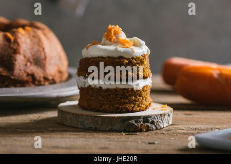 Mini-Karotten-Kuchen, gefüllt mit Frischkäse auf rustikale Holzplatte, Nahaufnahme Stockfoto