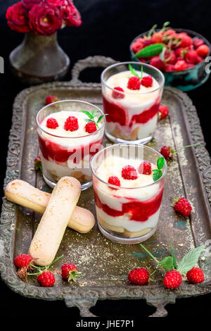 Tiramisu mit Himbeeren in Gläser auf Metalltablett. Drei Teil. Italienisches dessert Stockfoto