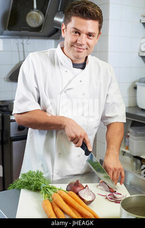 Portrait von Chefkoch Zubereitung Gemüse im Restaurant Küche Stockfoto