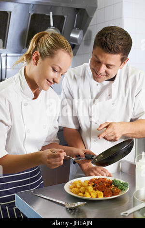 Koch anweist Trainee In Restaurantküche Stockfoto