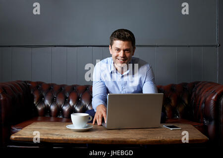 Porträt der Geschäftsmann arbeiten am Laptop im Internet-Cafe Stockfoto