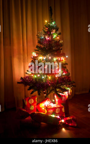 geschmückter Weihnachtsbaum mit verpackte Geschenke unter Stockfoto