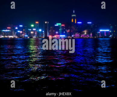 Blick auf Skyscrappers glänzend mit bunten Lichtern in Hong Kong Bucht bei Nacht Stockfoto