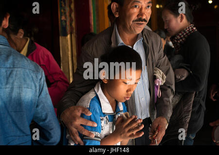 Ein Alter Mann mit seinem Sohn im Kloster Tsepak Lhakhang, Lhasa, Tibet. Stockfoto