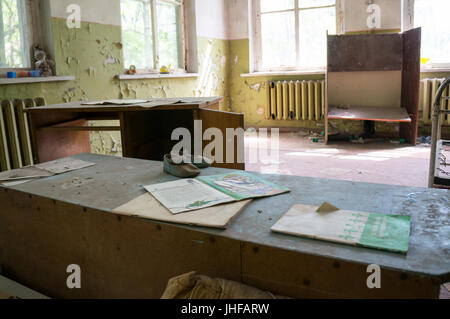 Kinderbücher auf einem staubigen Schreibtisch in Tschernobyl Stockfoto