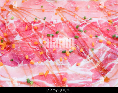 Frisches Schweinefleisch Scheiben und Gewürz Sauce mit Frühlingszwiebeln und Karotten für die Dekoration im Restaurant. Stockfoto