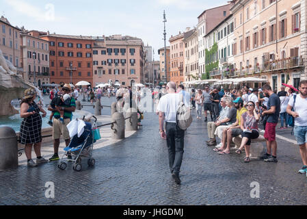 2017 - Touristen an einem sonnigen Tag neben dem Brunnen auf der Piazza Navona in Rom Stockfoto