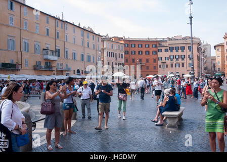 2017 - Touristen an einem sonnigen Tag neben dem Brunnen auf der Piazza Navona in Rom Stockfoto