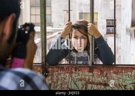 Junge Frau, die hinter den bars Stockfoto