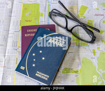 Planen Sie eine Reise - brasilianische und italienische Pässe auf Stadt Karte mit Brille Stockfoto