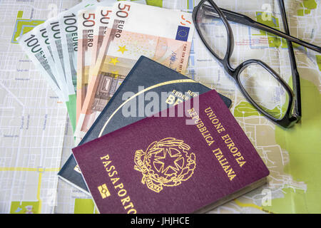 Planen Sie eine Reise - italienischen und brasilianischen Reisepass auf Stadtplan mit Euro Rechnungen Geld und Gläser Stockfoto