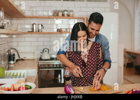 Schuss des romantischen junges Paar Hacken Gemüse zusammen in der Küche. Junger Mann und Frau gemeinsam kochen Essen zu Hause. Stockfoto