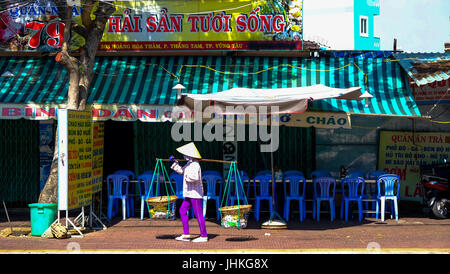 Ein weibliche vietnamesische Anbieter totes ihre waren entlang einer Straße in Ho-Chi-Minh-Stadt, Vietnam Stockfoto