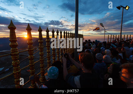 ADAM'S PEAK, SRI LANKA, 11. März 2016 Sonnenuntergang auf dem Gipfel Adam es Peak, Heiliger Berg von Sri Lanka. Pilger betet. Stockfoto