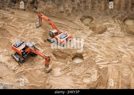 Bagger im Sandkasten bei Erdbau arbeiten. Bau von Betonfundament des Neubaus. Stockfoto