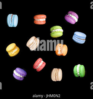 Bunte Makronen isoliert auf schwarzem Hintergrund fallen oder fliegen in Bewegung. Traditionelle französische Dessert macarons Stockfoto