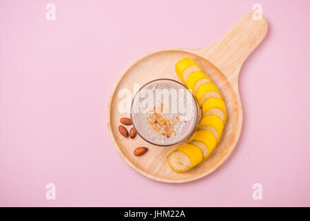 Frisch gemacht Banane Smoothie in einem Glas auf rosa Hintergrund Stockfoto