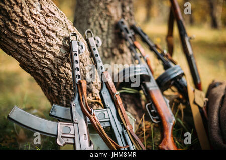 Sowjetische russische militärische Munition Waffe des zweiten Weltkrieges. PPS-43 und PPSh-41 Submachine Gun Baumstamm gelehnt. Waffe der Roten Armee. Stockfoto