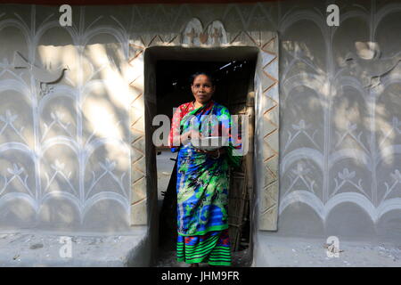 Eine Frau von Santal Indianergemeinde steht vor ihrem traditionellen Schlamm Haus Tikoil Dorf in Nachole Upazila Chapainawabganj Bezirk b Stockfoto