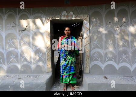 Eine Frau von Santal Indianergemeinde steht vor ihrem traditionellen Schlamm Haus Tikoil Dorf in Nachole Upazila Chapainawabganj Bezirk b Stockfoto