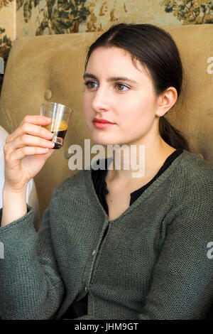 Eine junge Frau hält eine kleine Tasse Espresso. Stockfoto