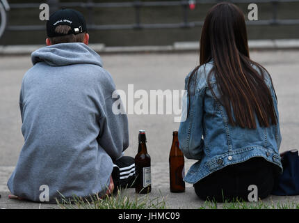 Berlin, Deutschland. 13. Juli 2017. Zwei junge Leute sitzen mit Bierflaschen in den frühen Abendstunden im Monbijoupark in Berlin, Deutschland, 13. Juli 2017. Foto: Paul Zinken/Dpa/Alamy Live News Stockfoto