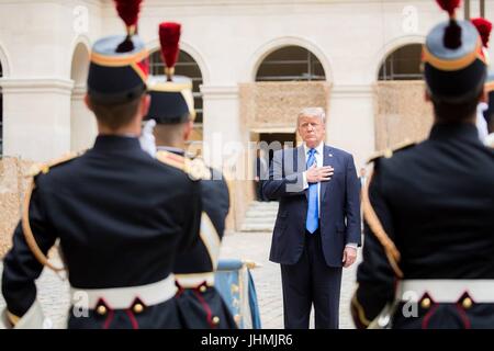 US-Präsident Donald Trump steht für das Abspielen der Nationalhymnen bei einem Besuch in Les Invalides Museum mit Frankreichs Präsident Emmanuel Macron 13. Juli 2017 in Paris, Frankreich. Die erste Familie ist in Paris zum Gedenken an den 100. Jahrestag der US-Gesundheitsbehörde Einstieg in Weltkrieg und Bastille-Tag feiern zu besuchen. Stockfoto