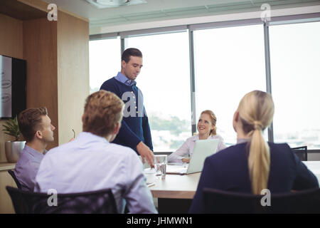 Geschäftsleute, die während der Sitzung im Sitzungssaal diskutieren Stockfoto