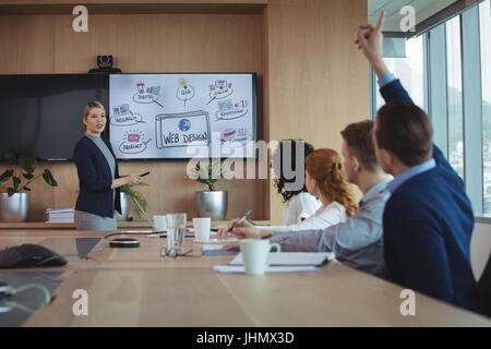 Geschäftsfrau, die Interaktion mit Team während der Sitzung am Konferenztisch im Sitzungsraum Stockfoto