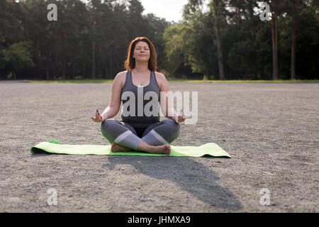 Schöne Übergrößen Mädchen meditieren Zuhause. Yoga und Wellness Konzept. Getonten Bild Stockfoto