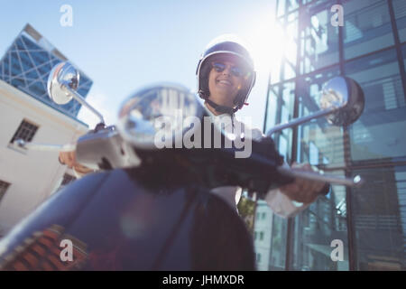 Niedrigen Winkel Ansicht Frau auf Motorroller an sonnigen Tag Stockfoto