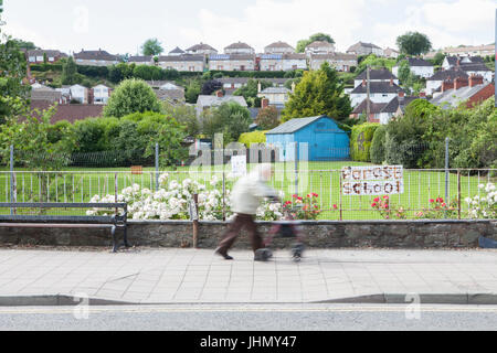 Ältere Frau, die zu Fuß in Welshpool Powys in Wales Stockfoto