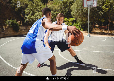 Freunde spielen Basketball vor Gericht Stockfoto