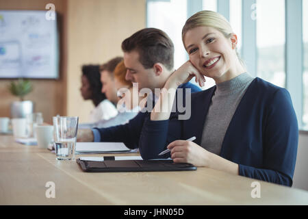 Porträt von lächelnden Geschäftsfrau sitzen am Schreibtisch im Büro Stockfoto