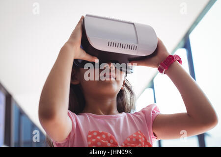 Niedrigen Winkel Ansicht des Mädchens mit virtual-Reality-Brille gegen die Decke im Flur in der Schule Stockfoto