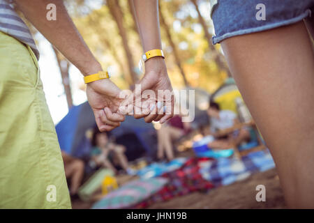 Zugeschnittenes Bild des Paares einhaken Pinky Finger im stehen am Campingplatz Stockfoto