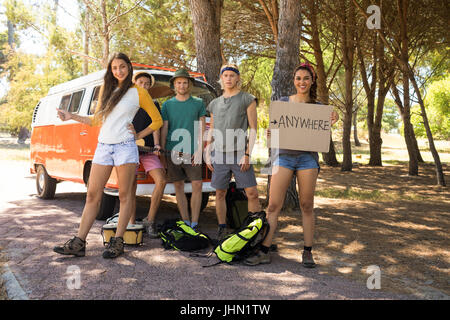 Porträt von Freunden Trampen stehend von Wohnmobil Stockfoto