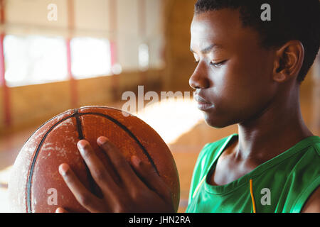 Teenager-Jungen Blick auf Basketball stehen vor Gericht Stockfoto