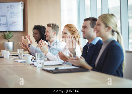 Glücklich Geschäftsleute klatschte während der Sitzung im Sitzungssaal am Konferenztisch Stockfoto
