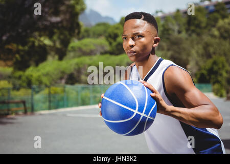 Männlichen Teenager halten Basketball beim üben im Gericht Stockfoto