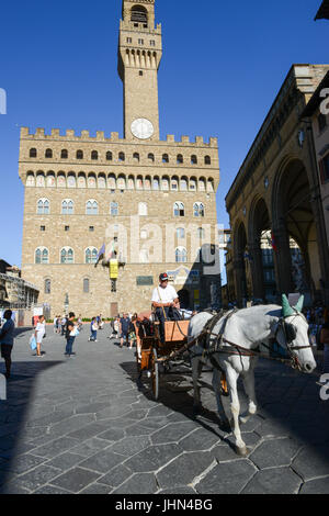 Firenze, Italien - 5. Juli 2017: Mann auf einer Pferdekutsche vor Palazzo Vecchio, das Rathaus an Florenz, Italien. Stockfoto