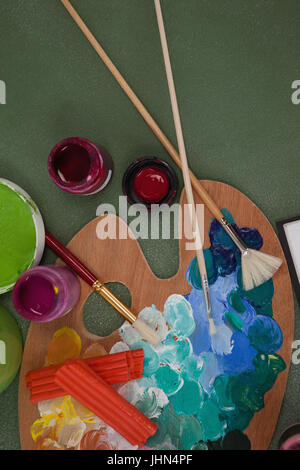 Draufsicht der Aquarellfarben und Pinsel an Tafel Stockfoto